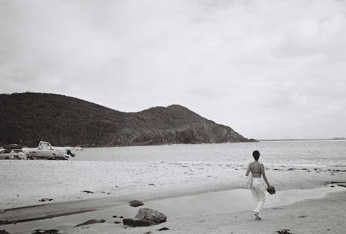 Black and White Picture of a Woman Walking on the Beach Alone