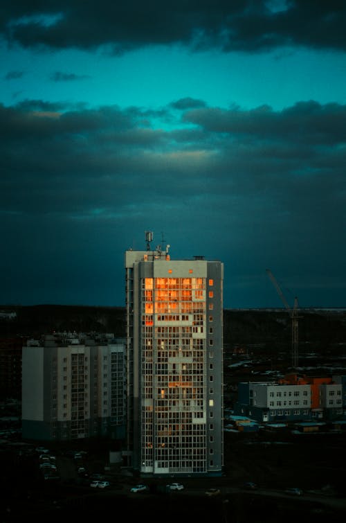 A Skyscraper Reflecting the Sunset on the Background of a Dark Sky 