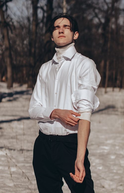 Free Elegant model in a white shirt poses fashionably in a snowy outdoor setting during the day. Stock Photo