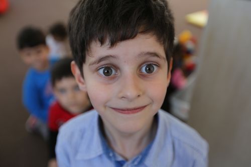 Free A surprised young boy with wide eyes looking directly at the camera, indoors. Stock Photo