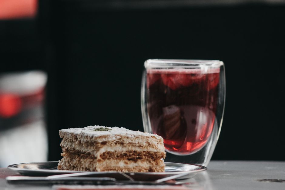 Delicious layered pastry served with a chilled beverage in a glass, perfect for a refreshing treat.