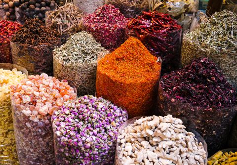 Open sacks of dried rosebuds, hibiscus, ginger root, red chilies and orange flower threads