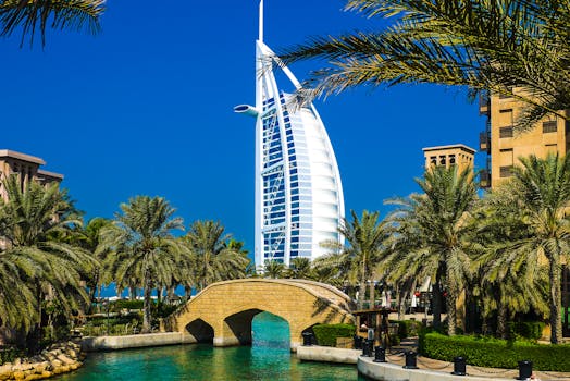 Scenic view of Burj Al Arab surrounded by lush palm trees and clear blue sky in Dubai.