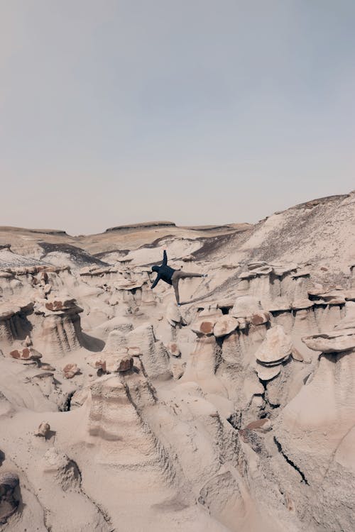 Man Posing on Rock Formations on Desert in USA