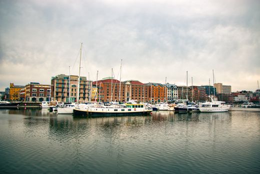 Boats moored in a harbour in front of a waterfront town — photo by Teja J on Pexels