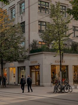 Stylish city street scene with Gucci and Chanel storefronts in Zürich, Switzerland.