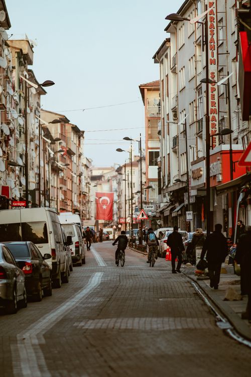 Free A vibrant Turkish street with people, cyclists, and the national flag in view. Stock Photo