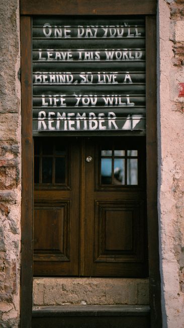 Inspirational text on a rustic door in an urban setting, conveying a memorable message.