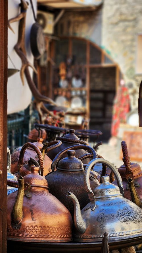Free A collection of vintage metal teapots displayed in a rustic outdoor market setting. Stock Photo
