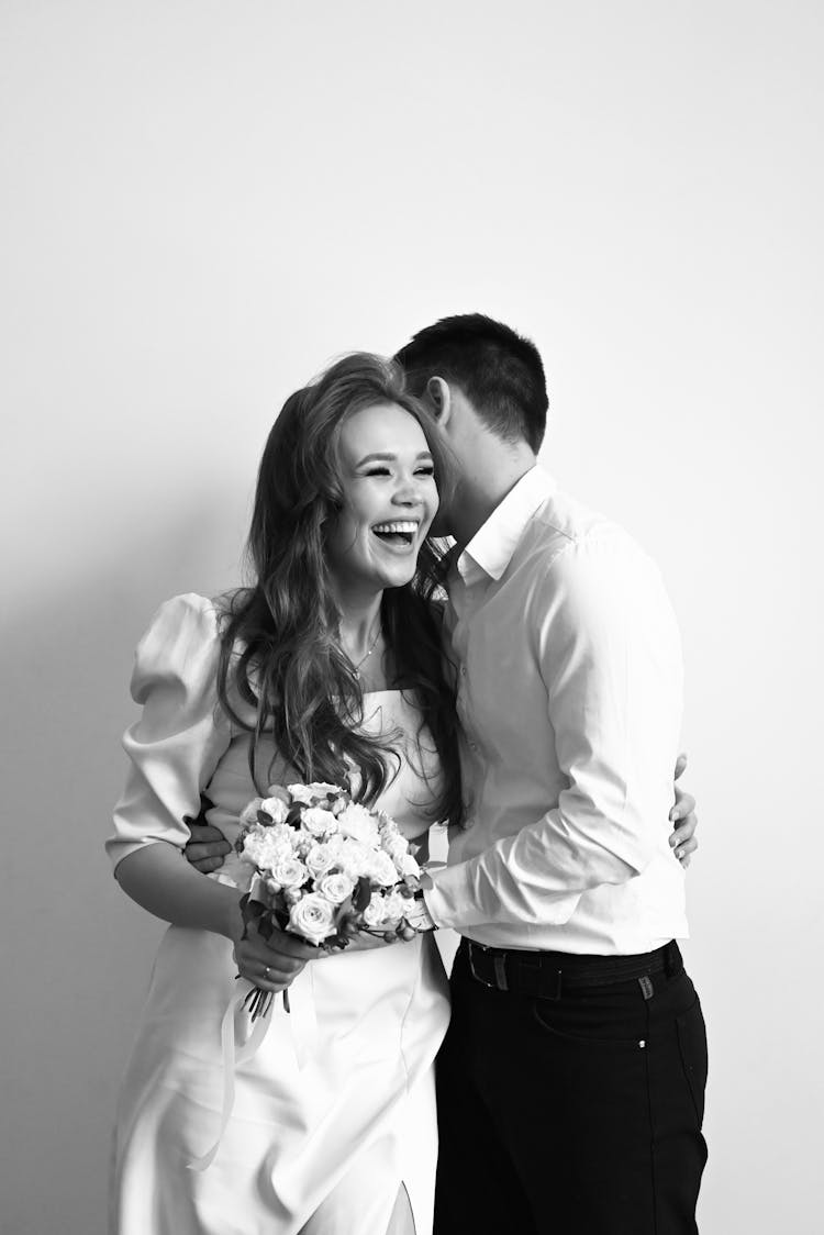 Black And White Photo Of A Laughing Wedding Couple Cuddling