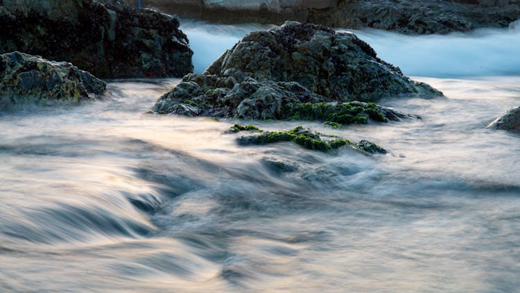 Water Around Rocks On Sea Shore