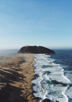 Breathtaking aerial view of the rugged coastline in Big Sur, California, during a sunny day.