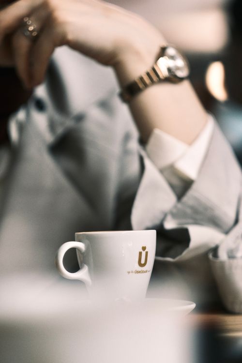 Free A close-up of a woman holding a coffee cup, wearing a wristwatch, creating a serene mood. Stock Photo