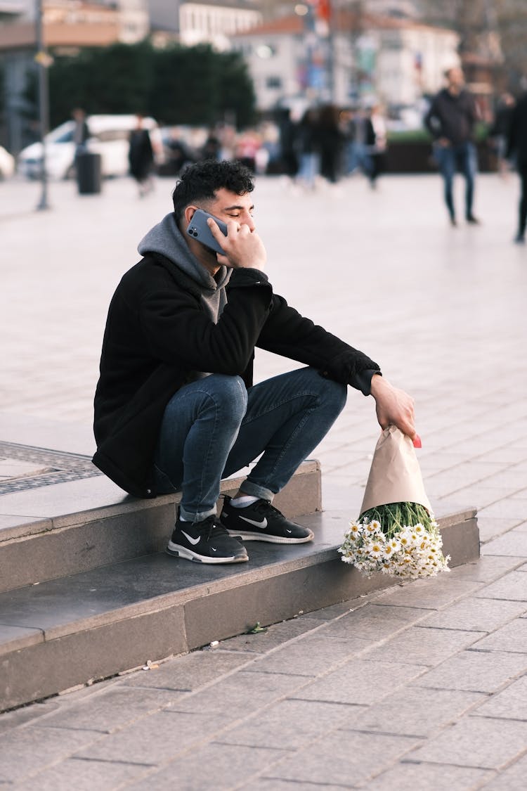 Photo Of A Young Man With A Bouquet Talking On The Phone