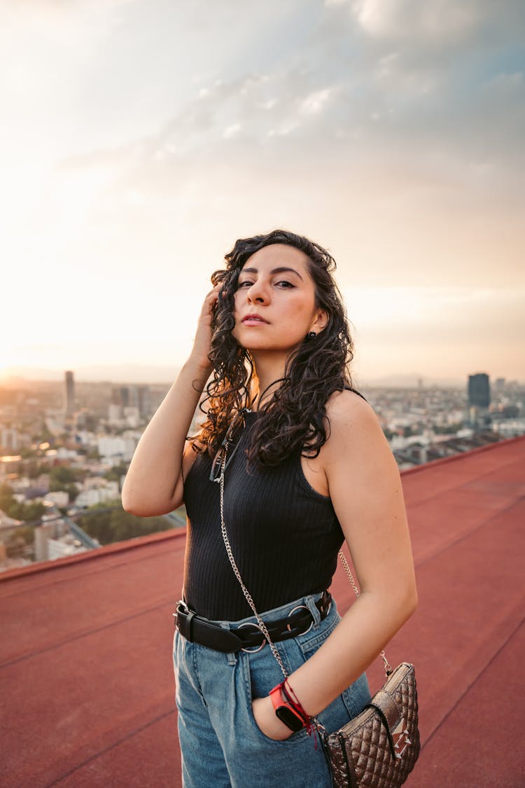 Woman Posing On A Red Roof, And Cityscape In Background