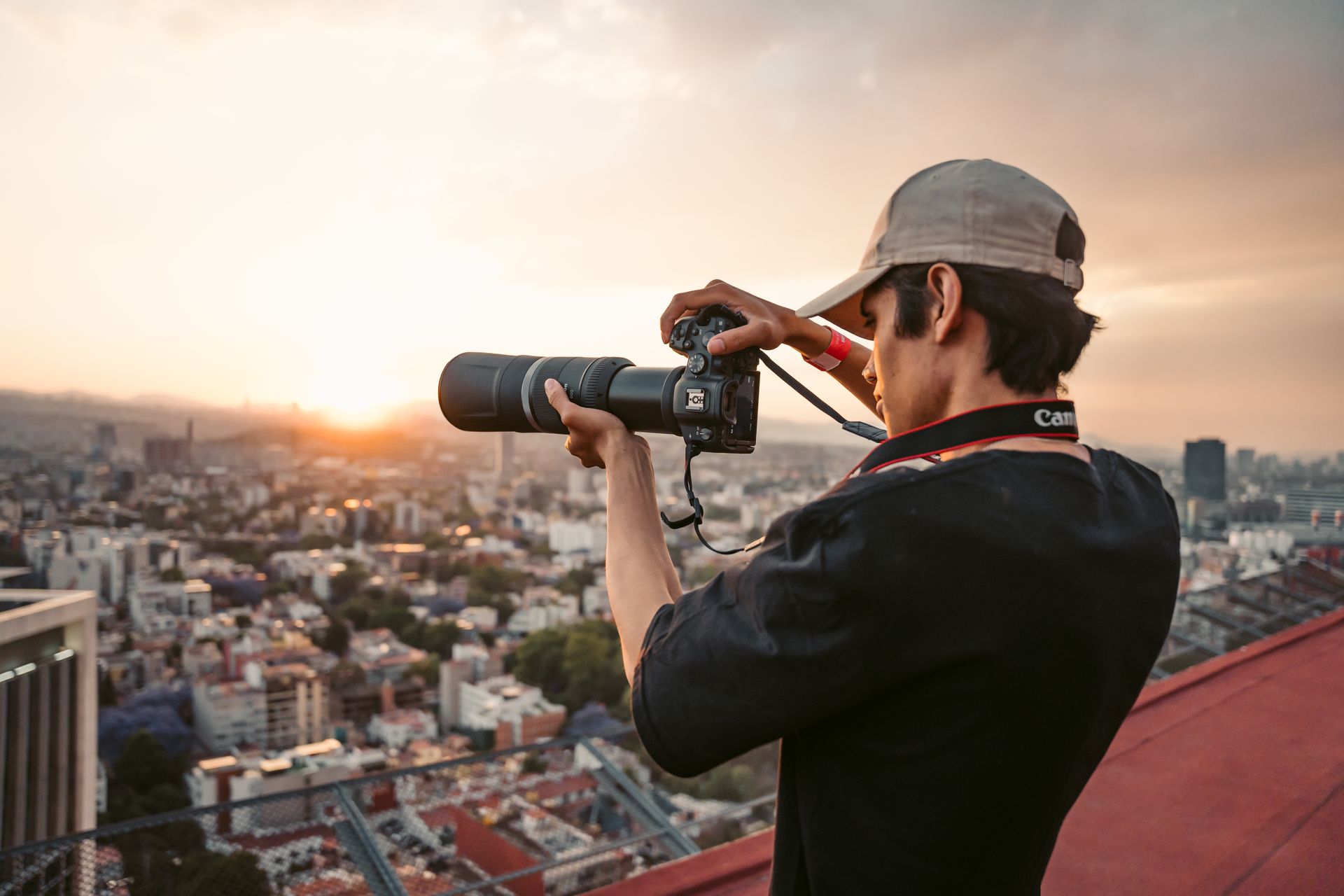 A photographer capturing the stunning sunset over Mexico City from a rooftop vantage point.