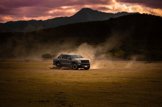 A pickup truck drives through a dusty field at sunset in Rioverde, Mexico, evoking adventure and freedom.