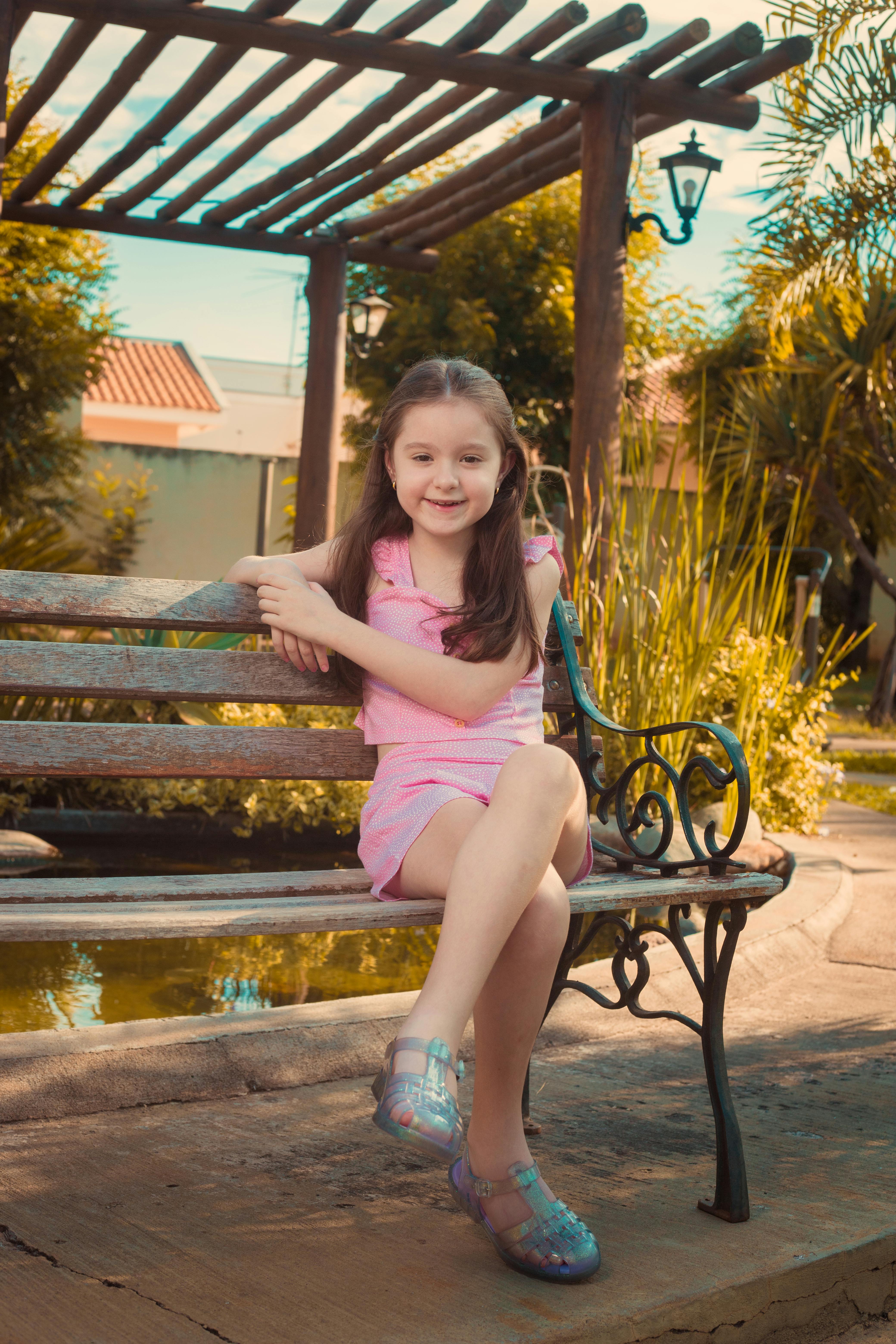 Cute Brunette Girl Sitting on Wooden Bench · Free Stock Photo