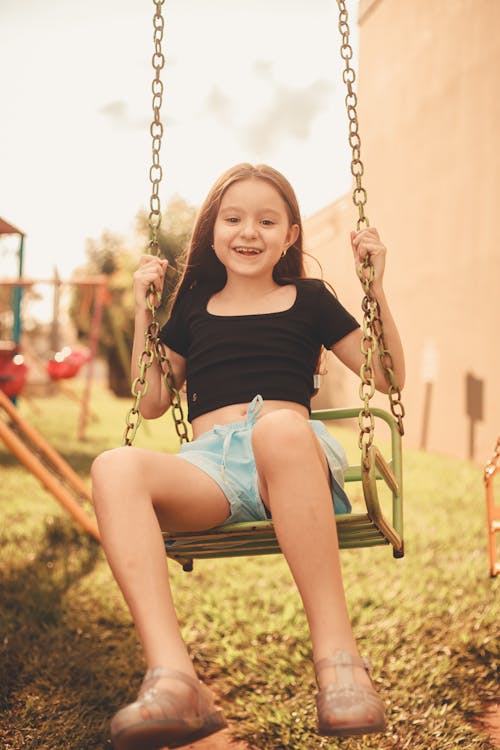 Brunette Girl Swinging in Playground