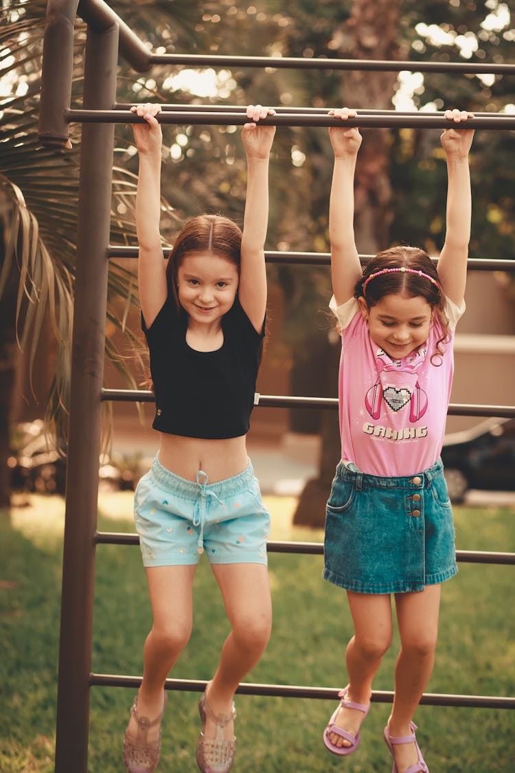 Smiling Girls Hanging On Bars