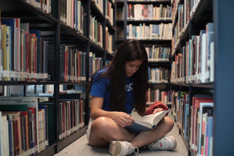 Woman Reading On Floor At Library