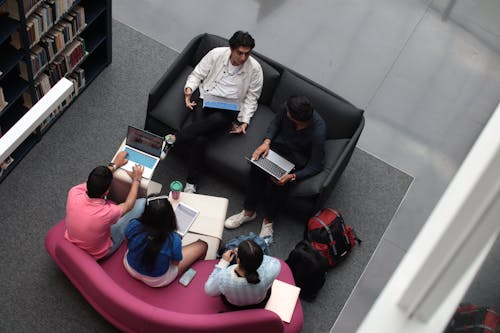 A Group of Students Sitting in a Library and Studying 