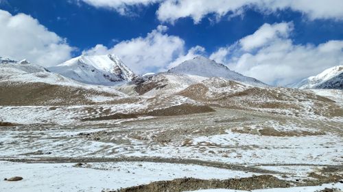 Free Breathtaking snowy mountain range with blue sky and clouds. Stock Photo
