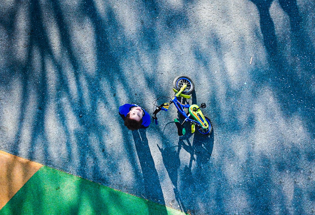 Top View Photo of Kid Near Bicycle