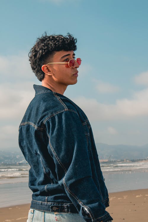 Young Man Wearing a Denim Jacket Posing on the Beach 