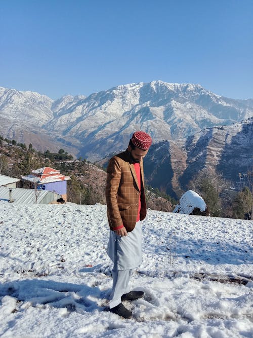 Man in Hat and Suit Posing in Mountains