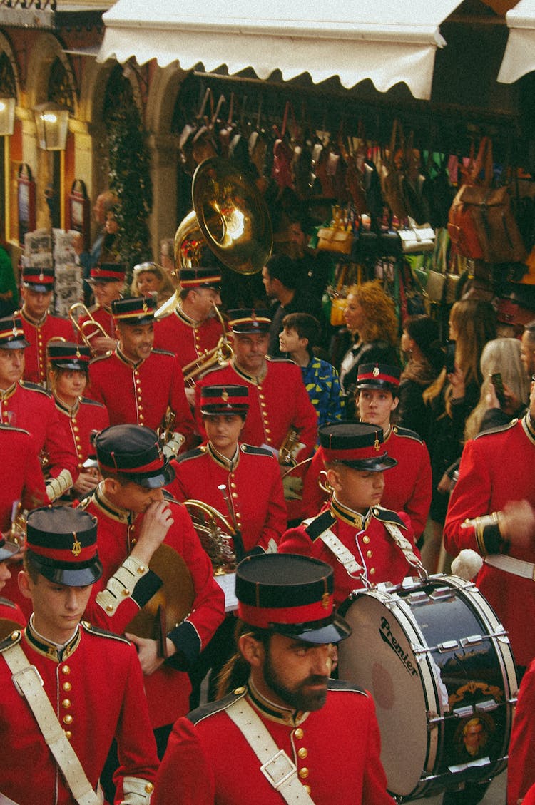 Soldiers In Red Uniforms Marching And Playing The Instruments In A Parade 