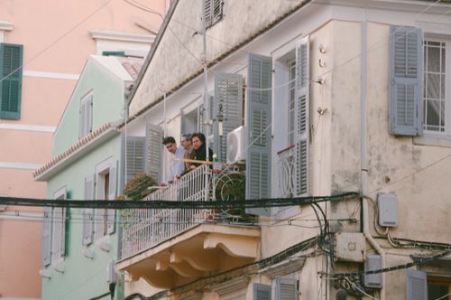 Free Candid scene of people on a classic Corfu balcony, depicting traditional Greek architecture. Stock Photo