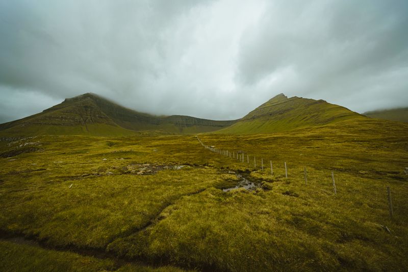 Green valley of coastal hills under an overcast sky, photo by Gije Cho on Pexels