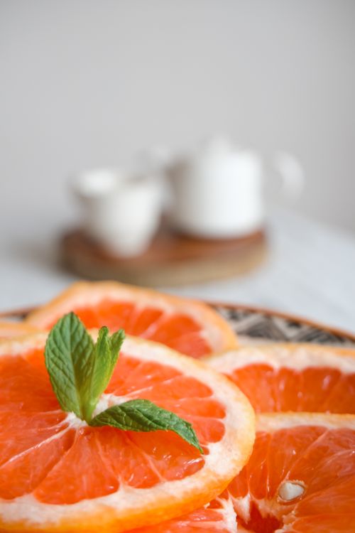 Free Close-up of fresh grapefruit slices garnished with mint leaves, perfect for health and refreshment themes. Stock Photo