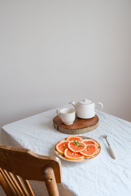 Free Minimalist still life of tea and fresh grapefruit slices on a table. Stock Photo
