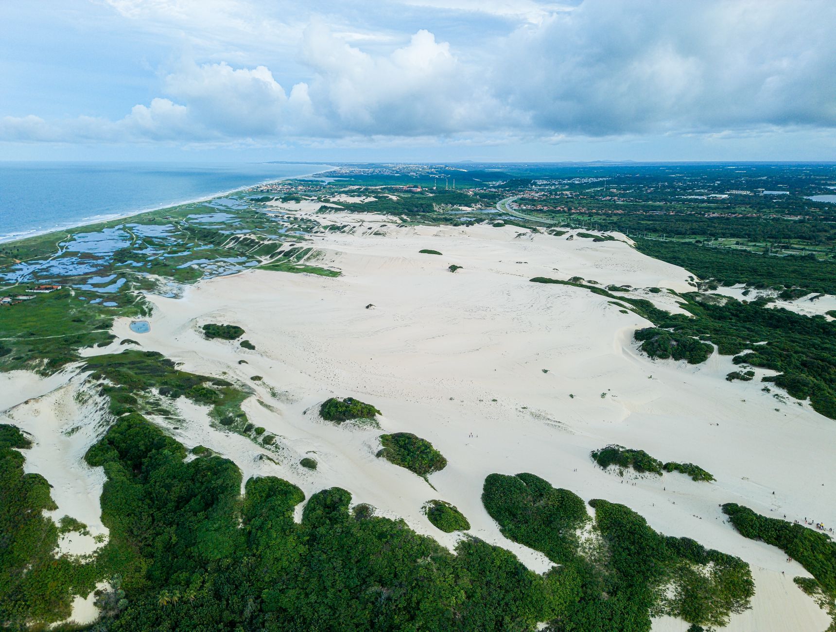 A stunning aerial view of sand dunes and coastline in Fortaleza, Brazil, showcasing desert landscape and ocean view.