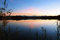 平静的湖泊倒映着色彩缤纷的日落天空，景象宁静