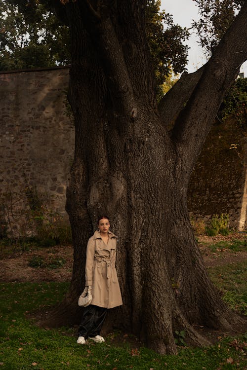 Woman in Coat Posing by Tree