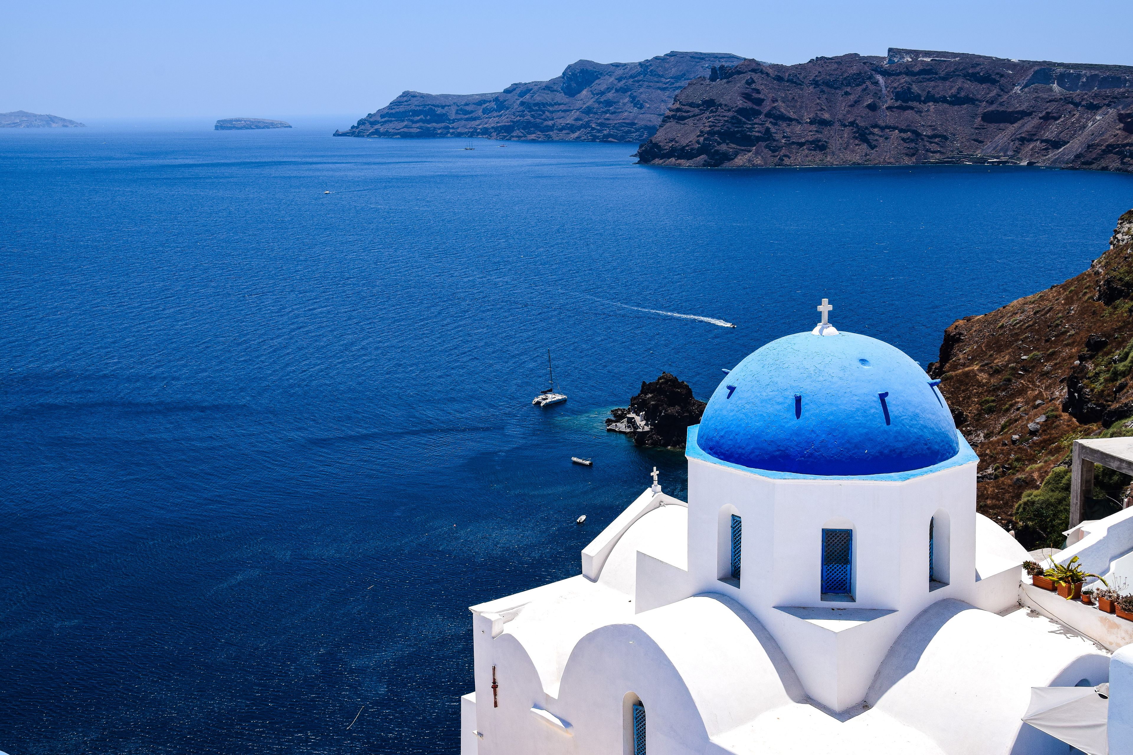 Experience the breathtaking beauty of Santorini's iconic blue-domed churches overlooking the Aegean Sea.