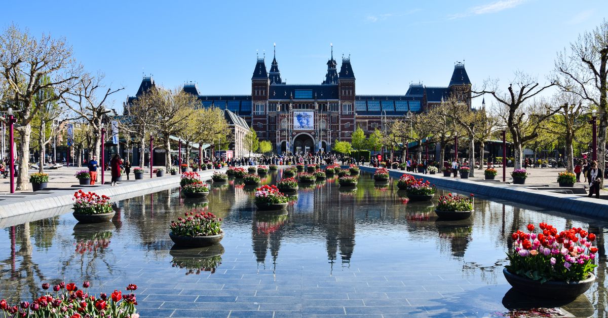 Rijksmuseum with gardens and reflecting pool in Amsterdam.