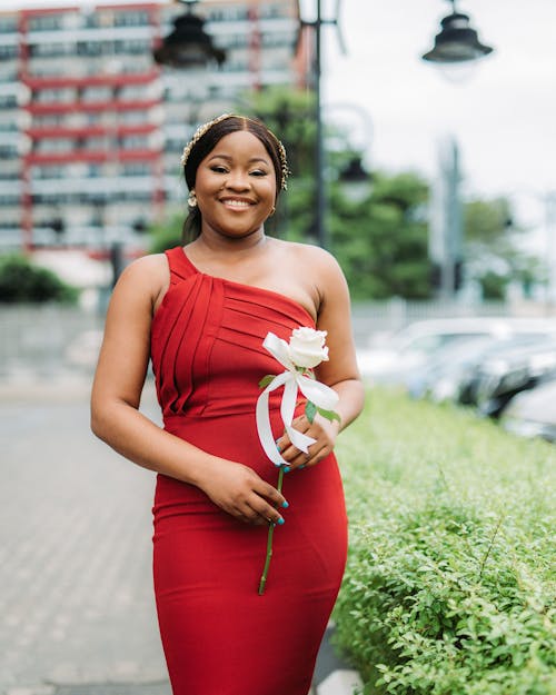 Smiling Woman in Red Dress Posing with Flower