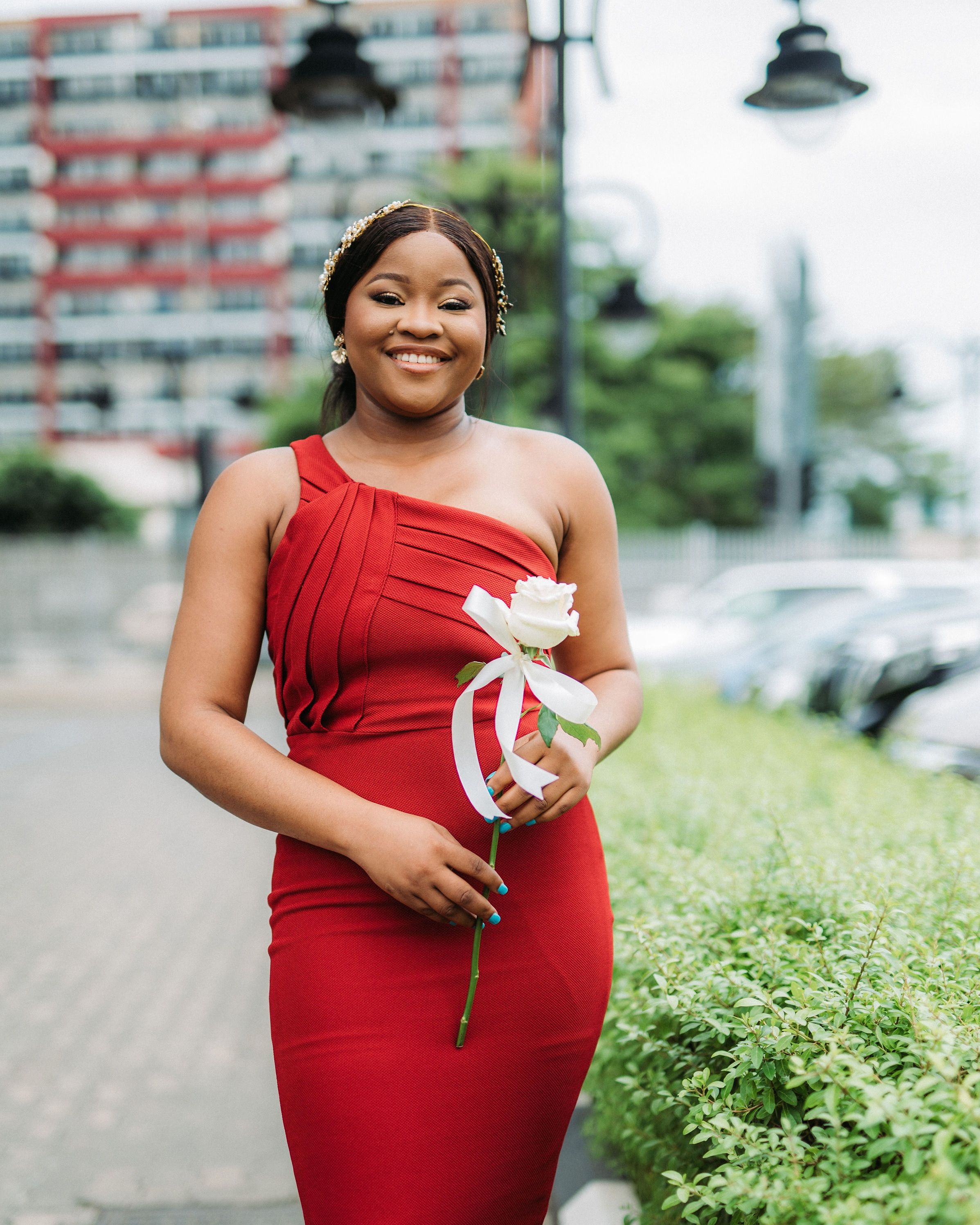 Smiling Woman in Red Dress Posing with Flower · Free Stock Photo