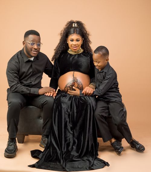 Free A joyful family portrait featuring a pregnant mother with her husband and son. Stock Photo