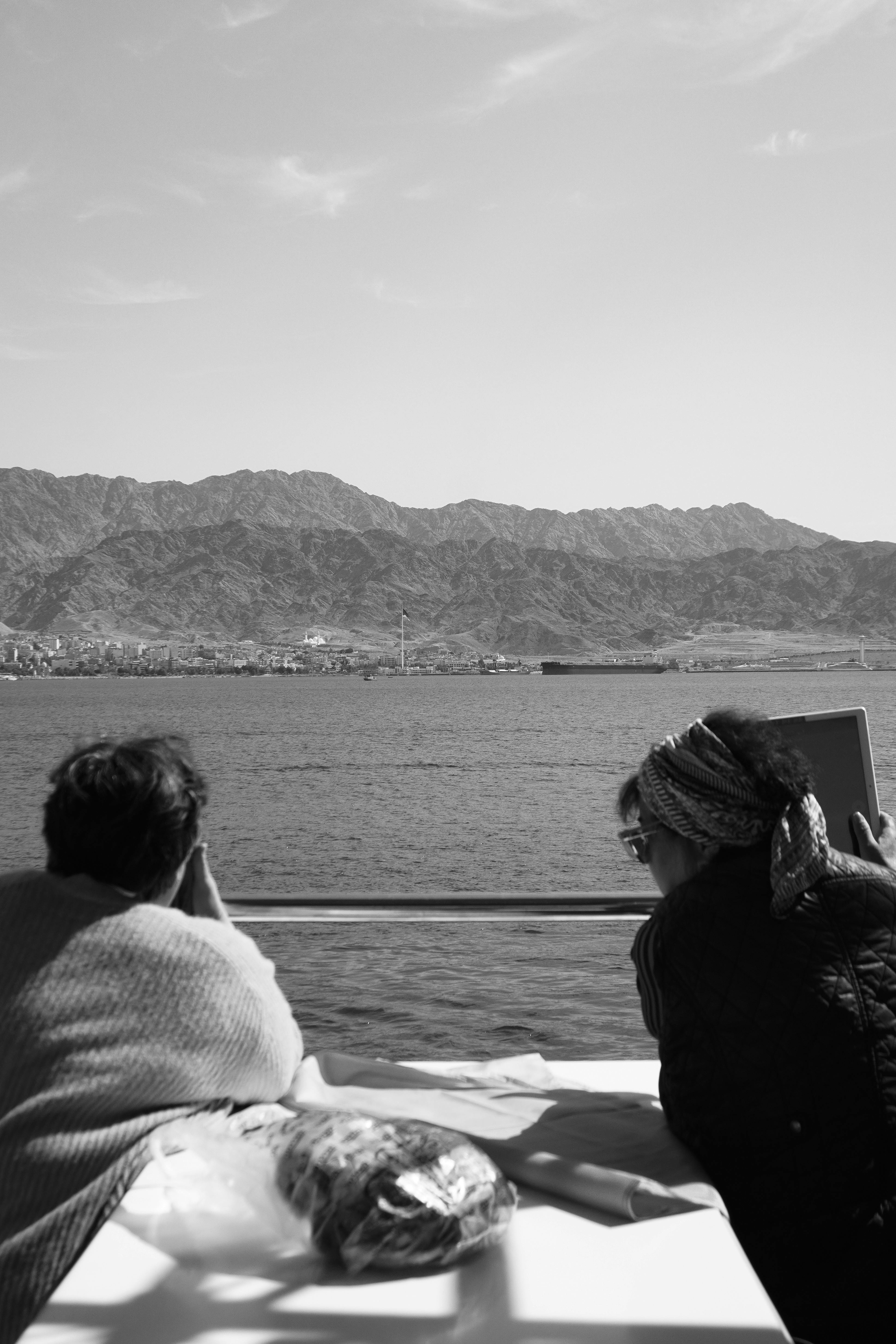 Relaxing black and white view from a boat in Eilat, overlooking the mountains.