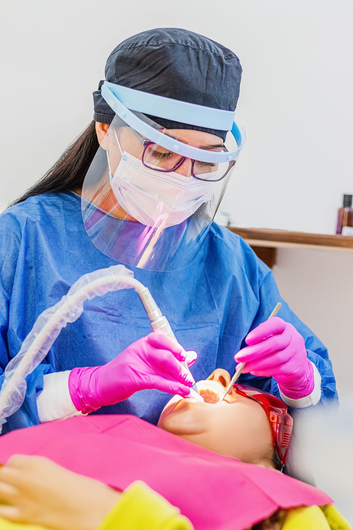 Dentist in protective gear providing urgent, same-day dental care