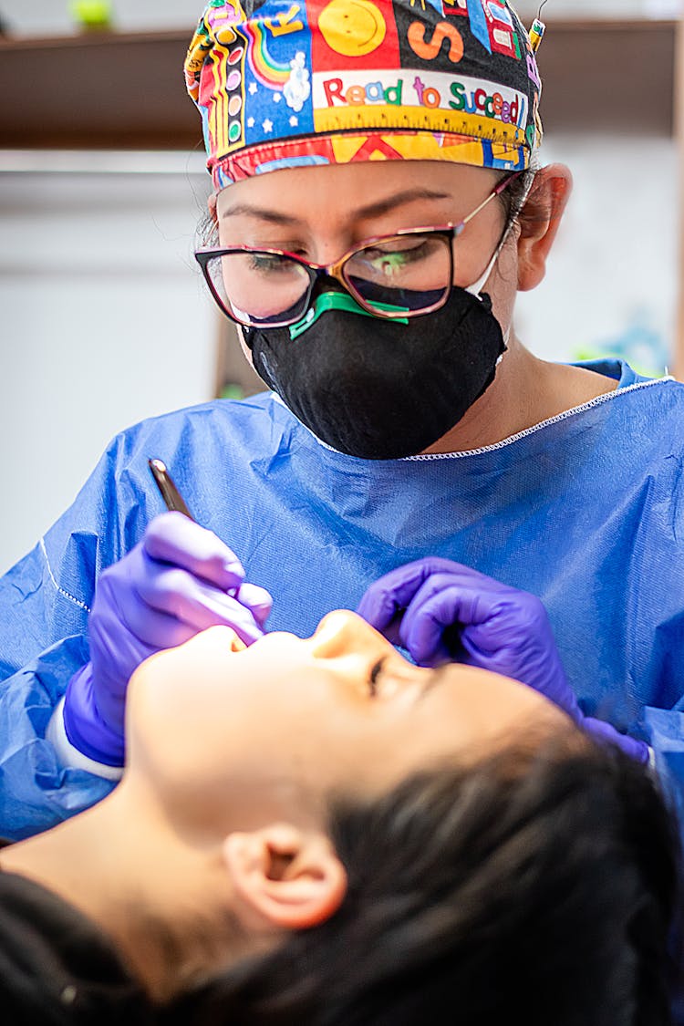 Female Dentist Treating A Patient 