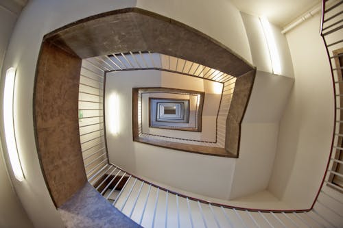 Low Angle Photo of Brown and White Spiral Stairs Building
