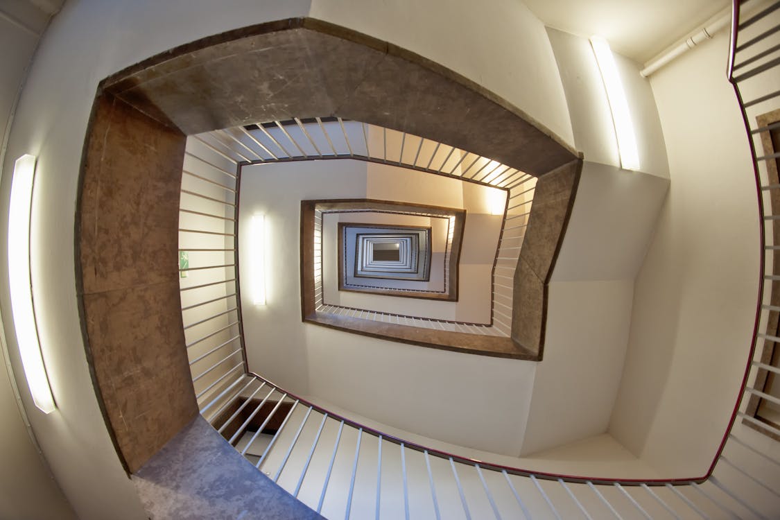 免费 棕色和白色螺旋楼梯大楼的低角度照片 素材图片