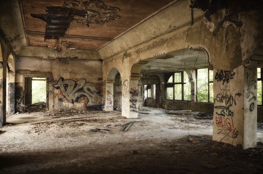 Explore the eerie charm of an abandoned building featuring intricate graffiti and dilapidated architecture.