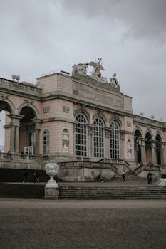Grand baroque palace with intricate sculptures, captured in Vienna under a moody sky.